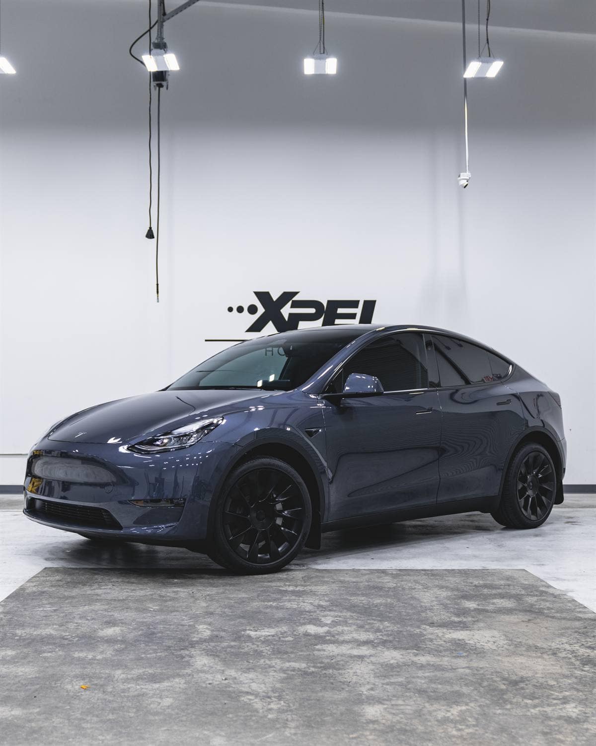 Tinted blue Tesla Model Y inside a Tint World Glenview service bay